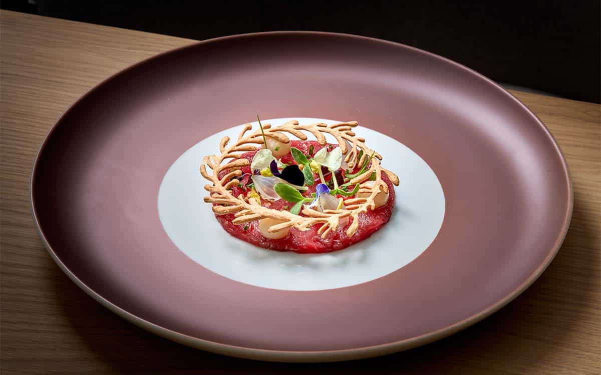 Carpaccio vom Weideochsen mit Sellerie, geflämmter Perlzwiebel und Senfkörnerragout